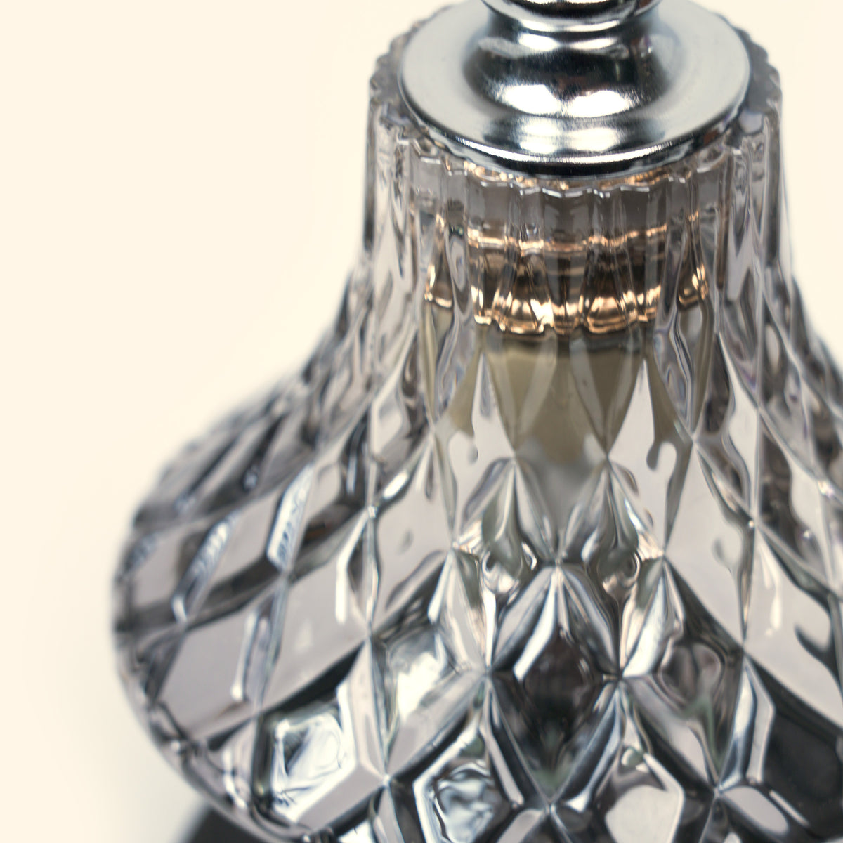 Close-up of the faceted diamond glass shade and chrome-toned top on the Vintage Diamond Candle Warmer Lamp.