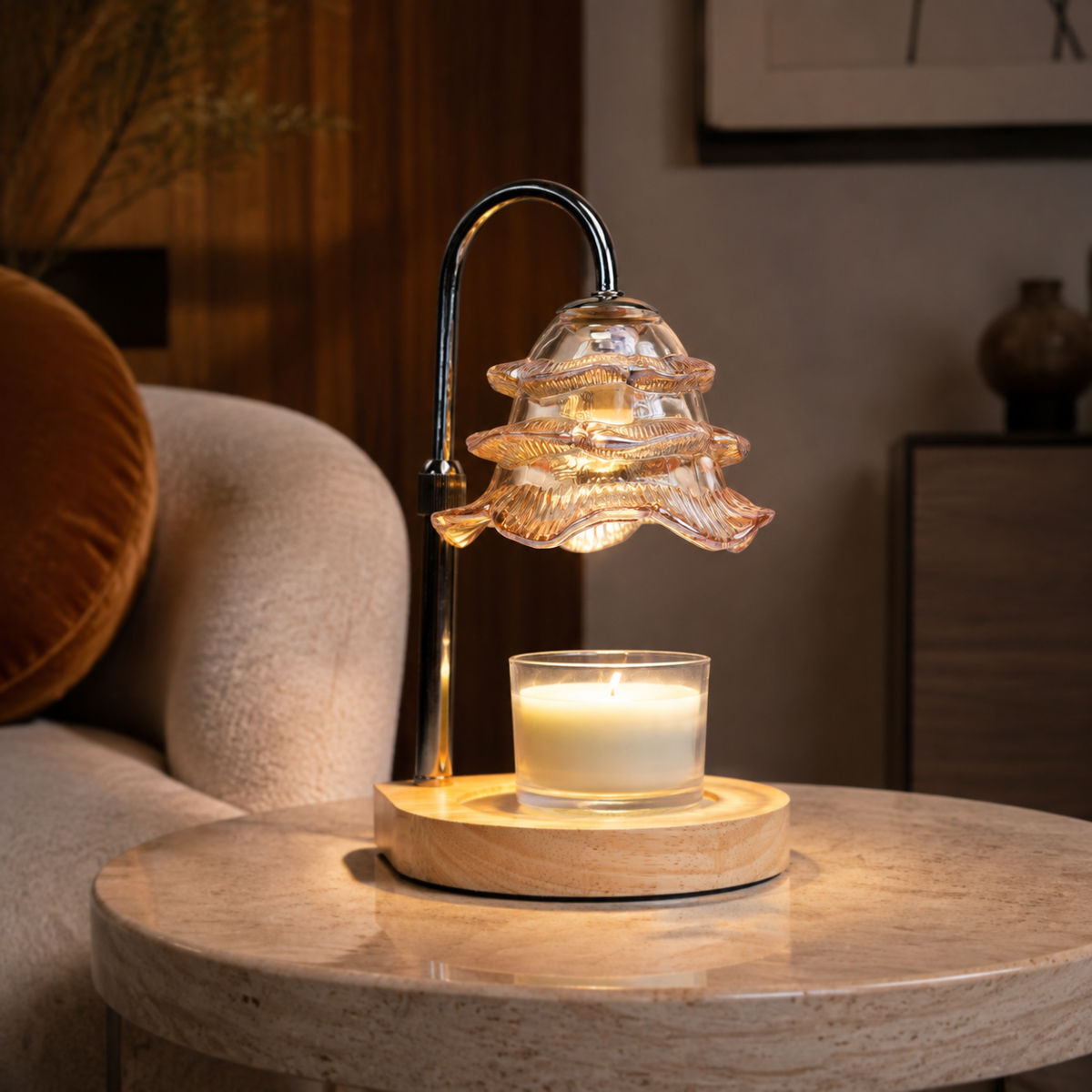 Champagne glass candle warmer glowing on a round stone side table beside a cream armchair.