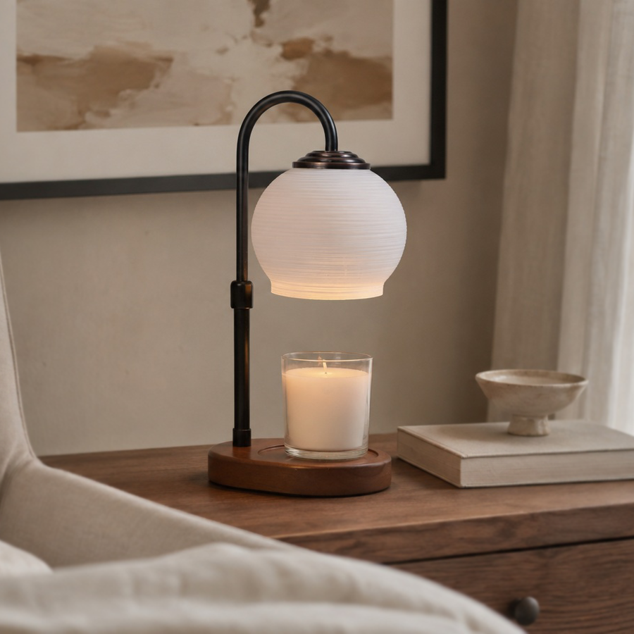 Textured Sphere electric candle warmer glowing on a wooden console beneath framed artwork.