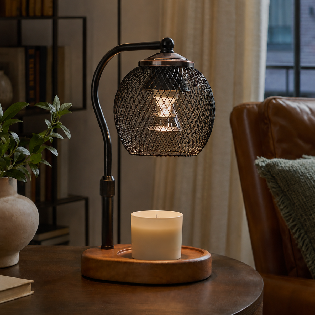 Spherical mesh candle warmer lamp displayed with a white jar candle in a neutral living room.