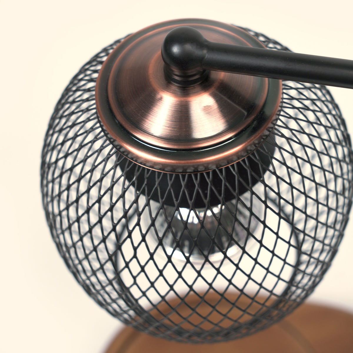 Close-up of the spherical diamond mesh shade and bronze-toned top on the Lattice Orb Candle Warmer Lamp.