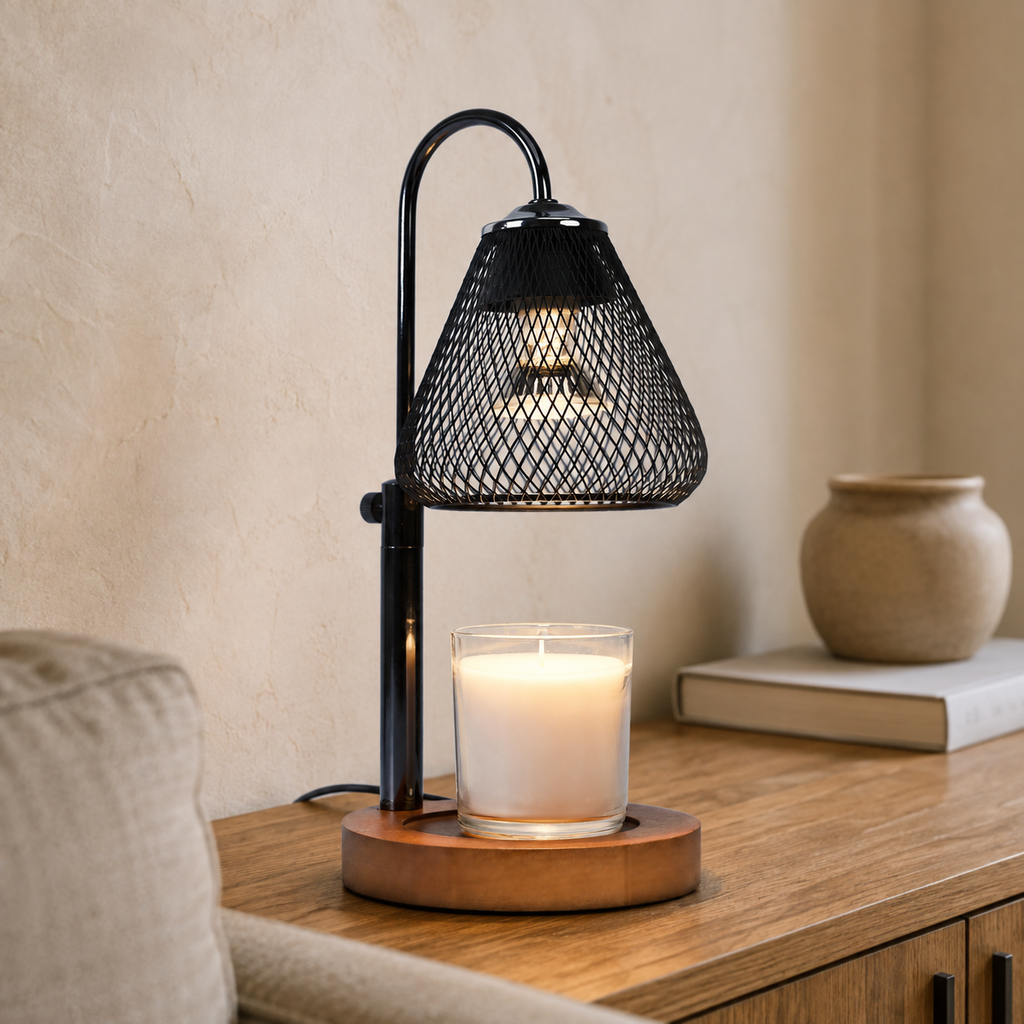 Lattice Bell candle warmer glowing over a white jar candle on a wooden cabinet beside a cream chair.