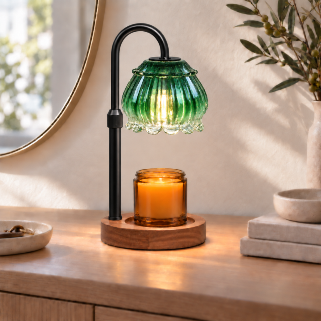 Emerald green glass candle warmer lamp with black arm displayed on an entryway console