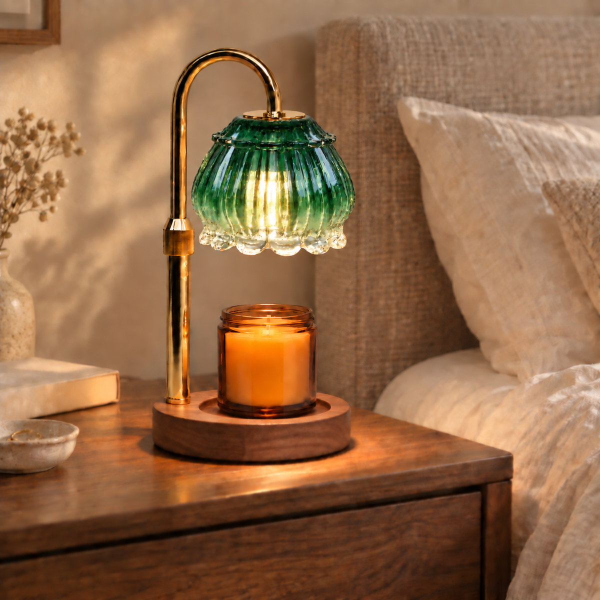 Emerald green glass candle warmer lamp with walnut base and gold arm on a bedroom bedside table