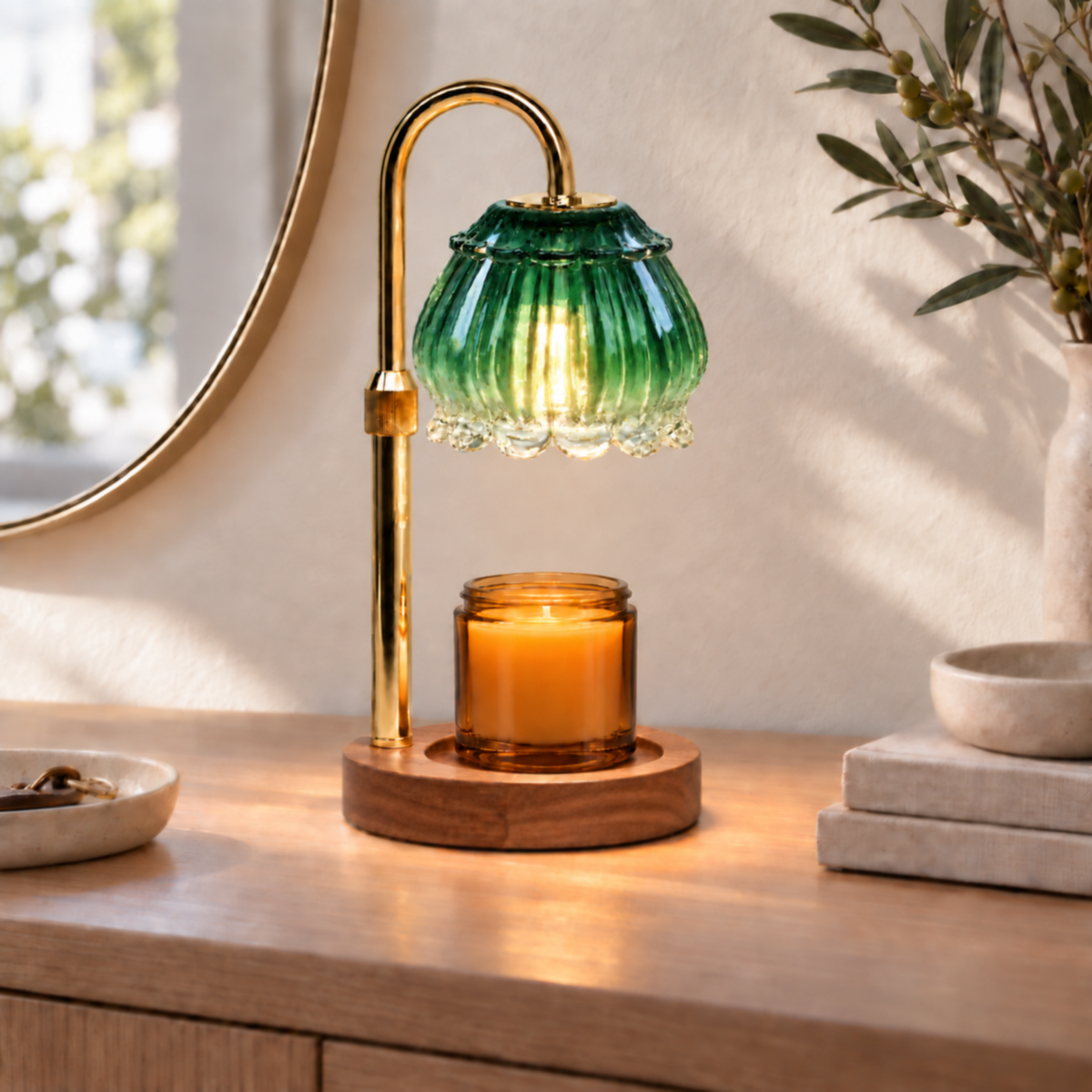 Emerald green glass candle warmer lamp displayed on an entryway console beneath a round mirror