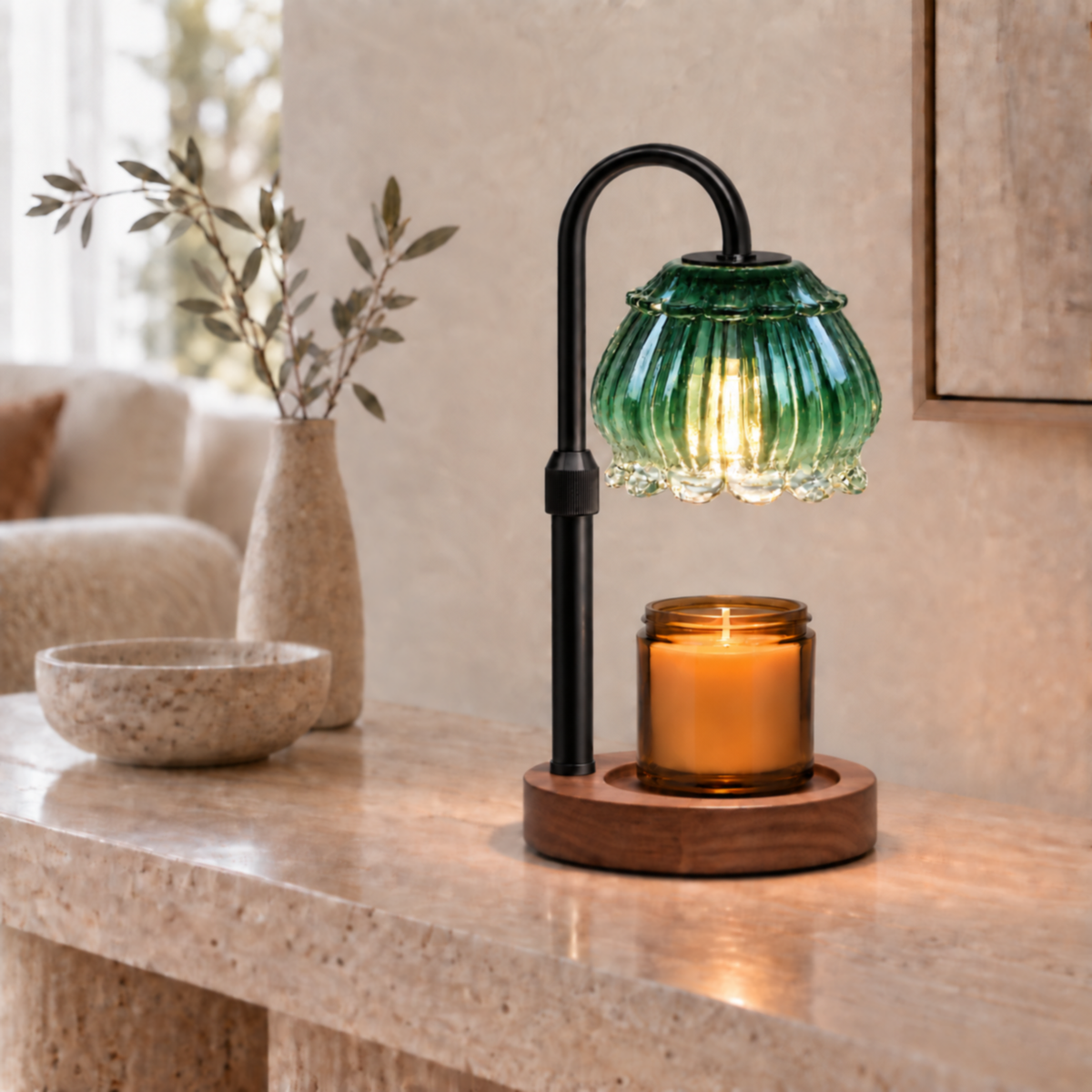 Emerald green fluted glass candle warmer lamp with black arm on a living room console