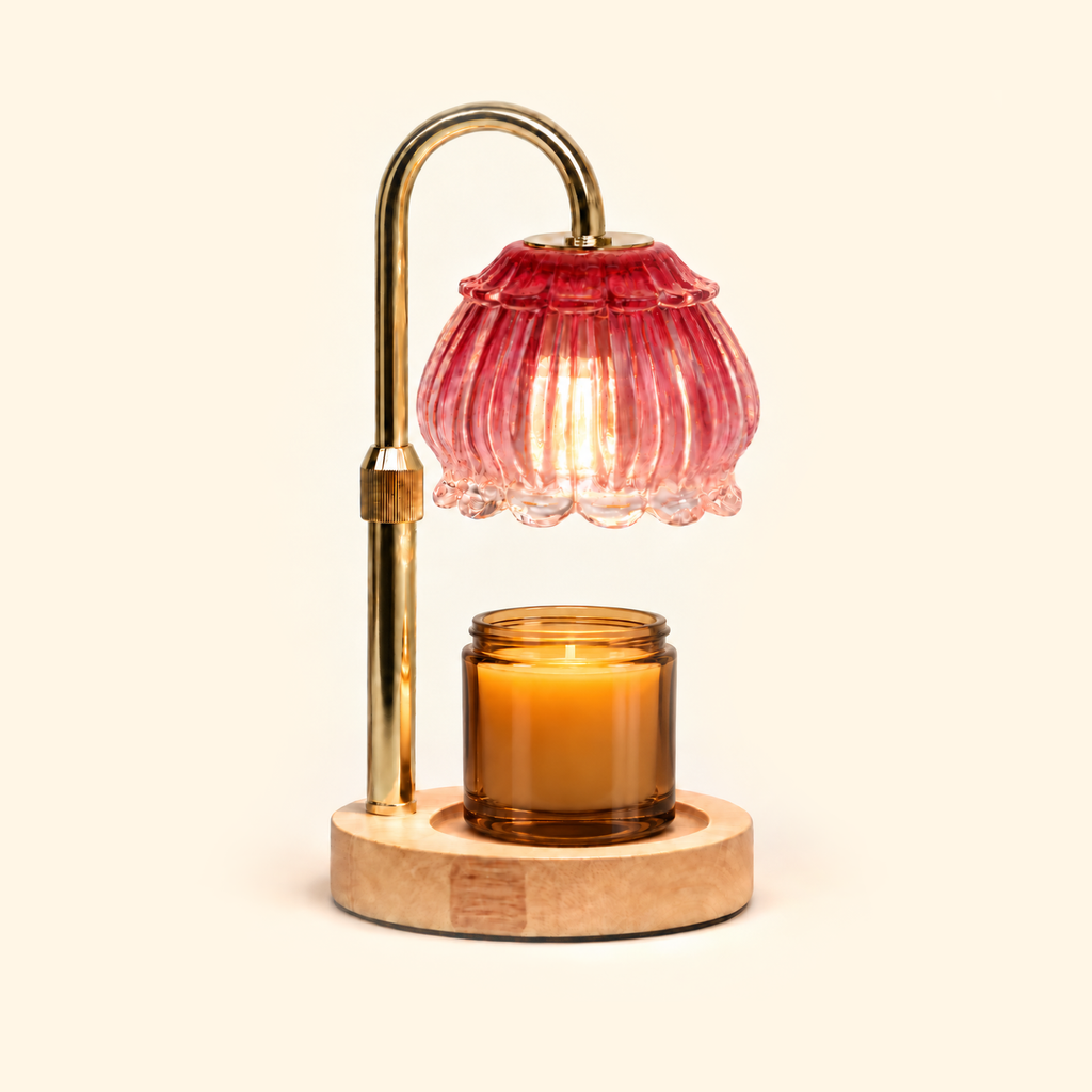 Ruby red glass candle warmer lamp warming an amber jar candle on a warm cream background