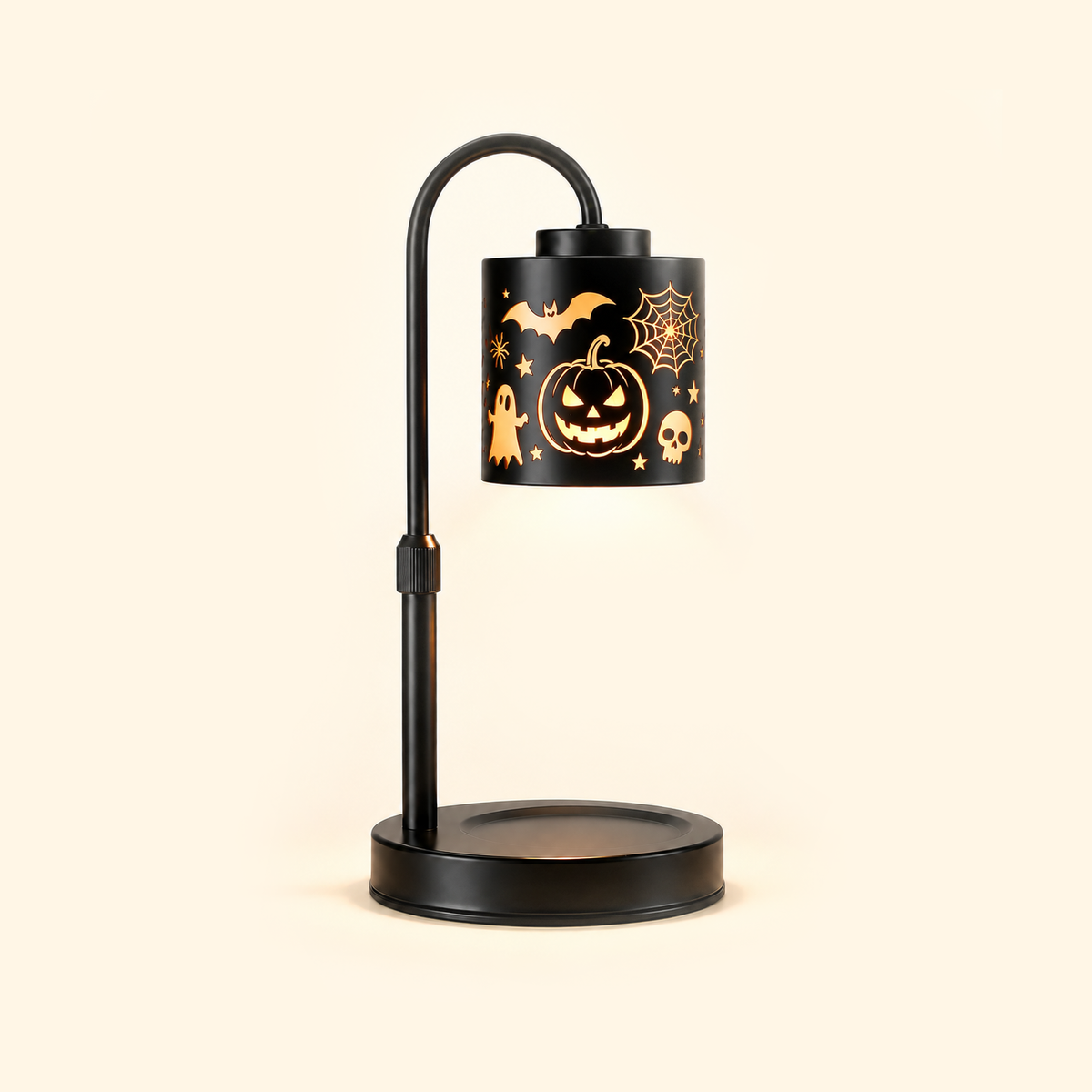 Black jack-o'-lantern candle warmer lamp illuminated without a candle on a cream background