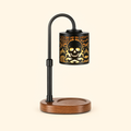 Skull and crossbones candle warmer lamp with walnut base illuminated without a candle