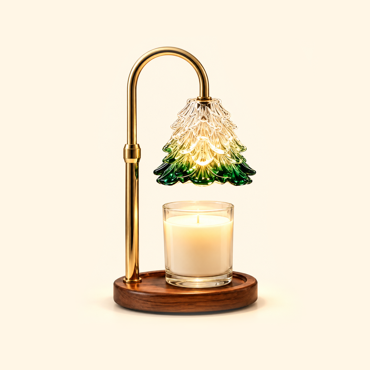 Gold candle warmer lamp with a clear and green tree-shaped glass shade, walnut base and jar candle on a cream background.
