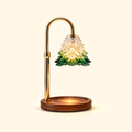 Gold candle warmer lamp with an illuminated tree-shaped glass shade and empty walnut base on a cream background.