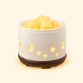 Moon & Stars Ceramic 2-in-1 Candle & Wax Warmer switched on with wax melts and glowing cutouts