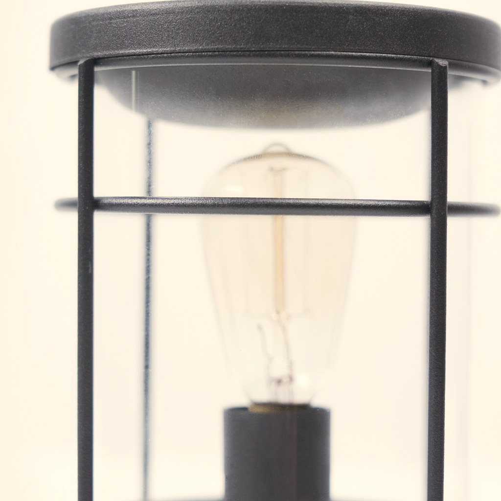 Close-up of the unlit clear bulb and black metal frame inside the Vintage Lantern wax warmer.