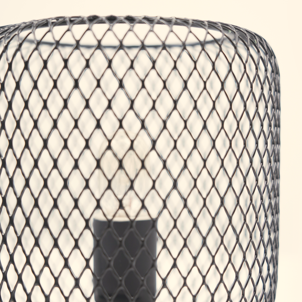 Close-up of the unlit bulb and black metal lattice structure on the column wax warmer.