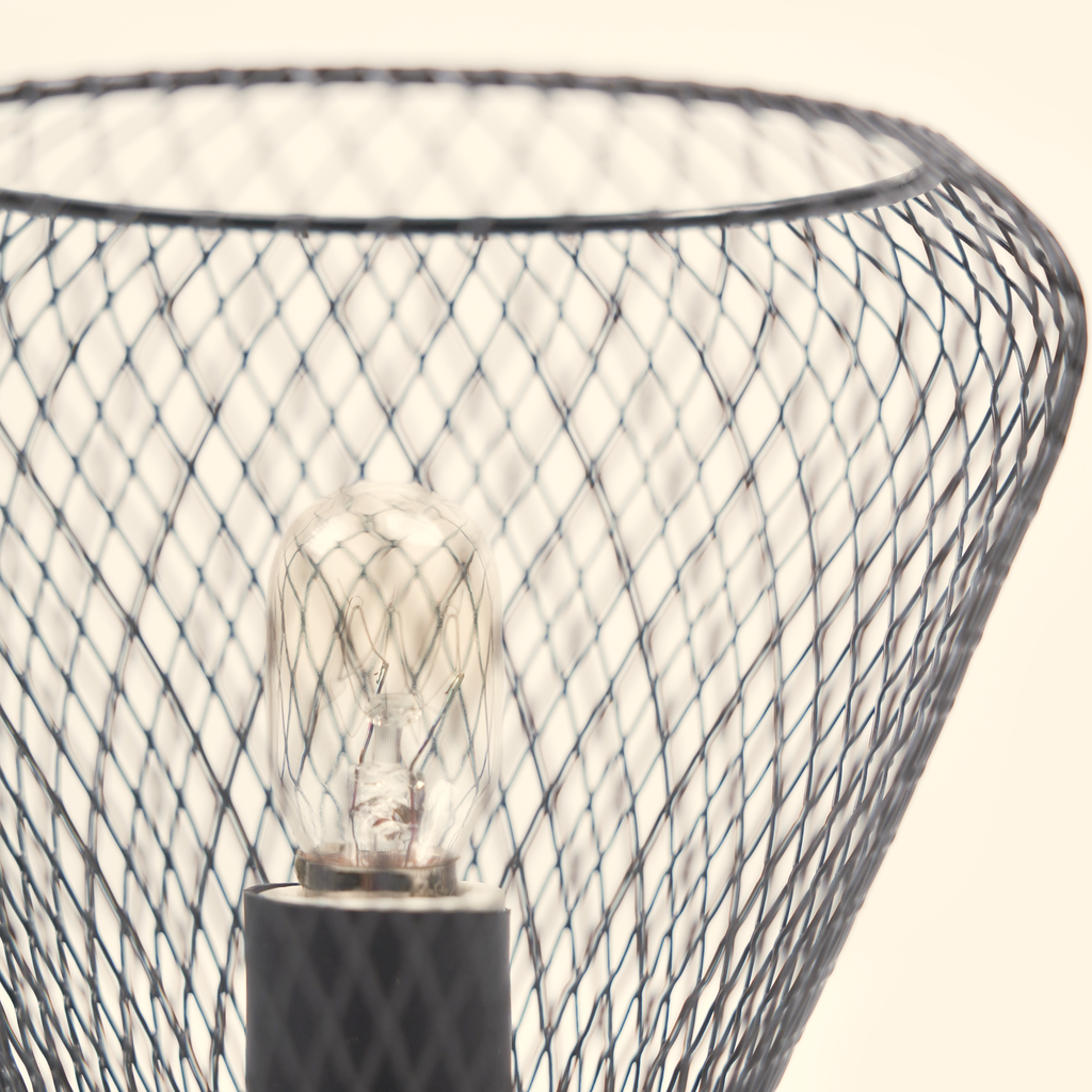 Close-up of the unlit clear bulb surrounded by the tapered black metal lattice.