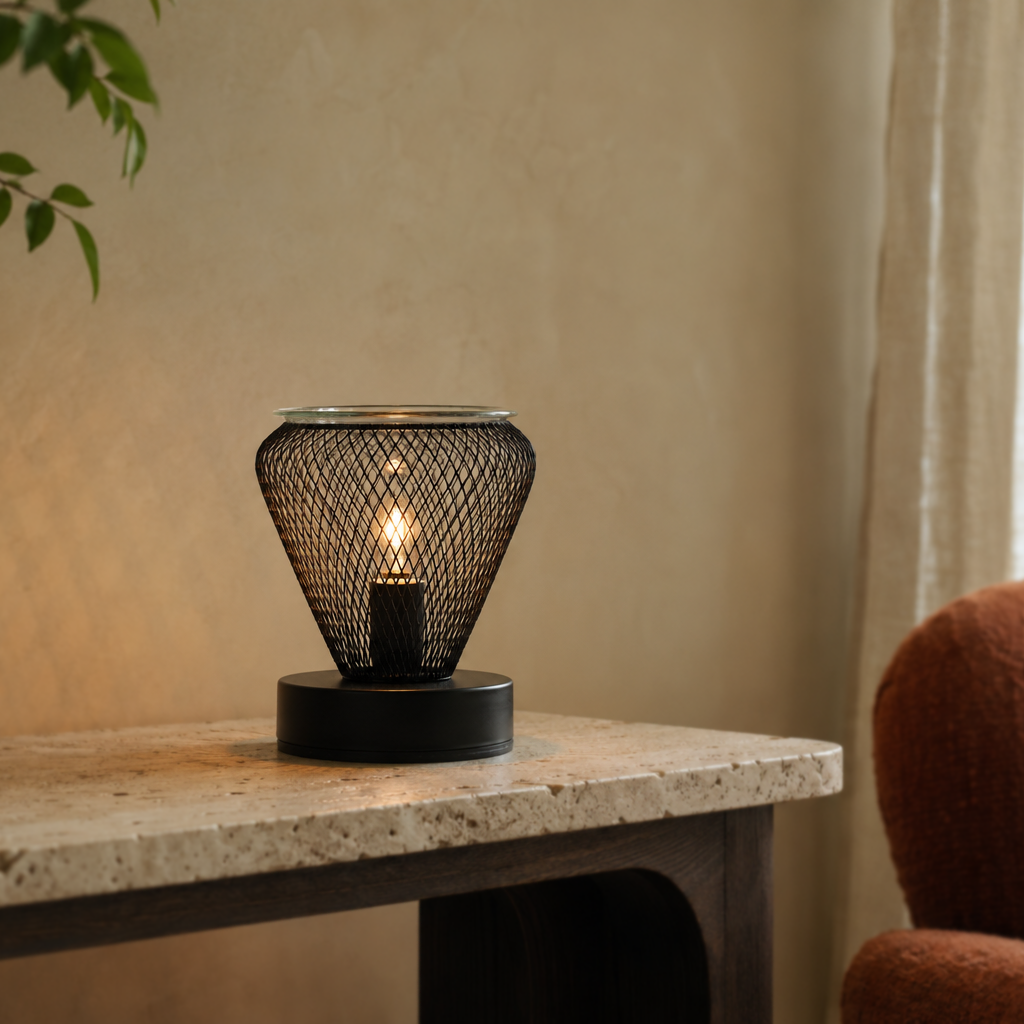 Noir Lattice Vase electric wax warmer glowing on a light stone table beside a rust-colored chair.