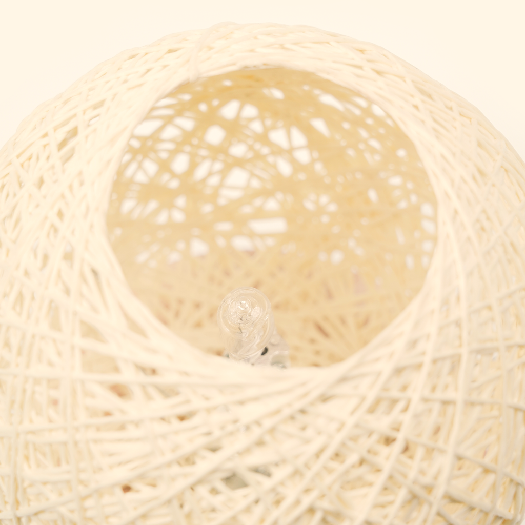 Close-up inside the woven globe showing the unlit clear bulb and layered hand-wrapped fiber texture.