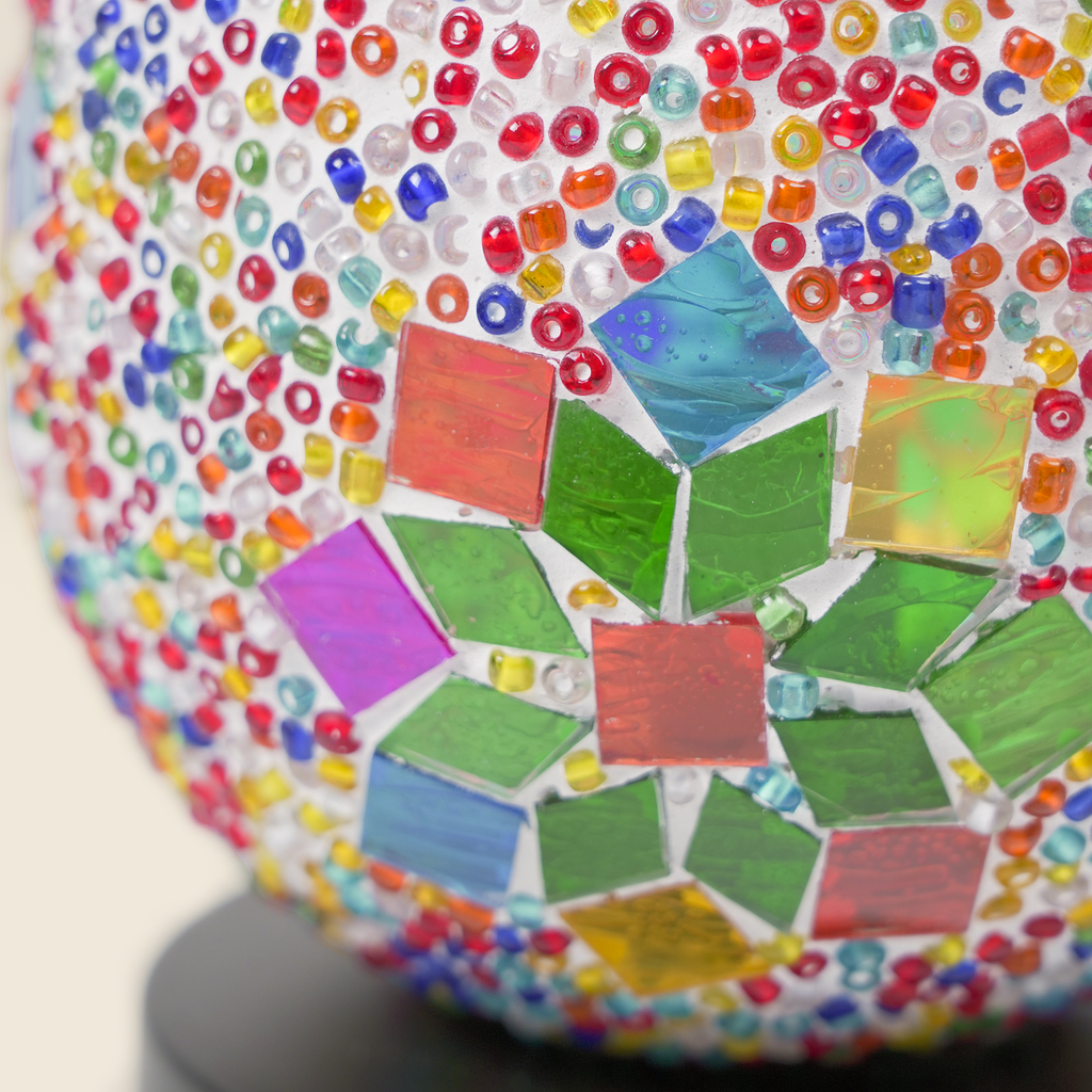 Close-up of the colorful glass beads and geometric mosaic pieces on the Mosaic Bloom Globe wax warmer.