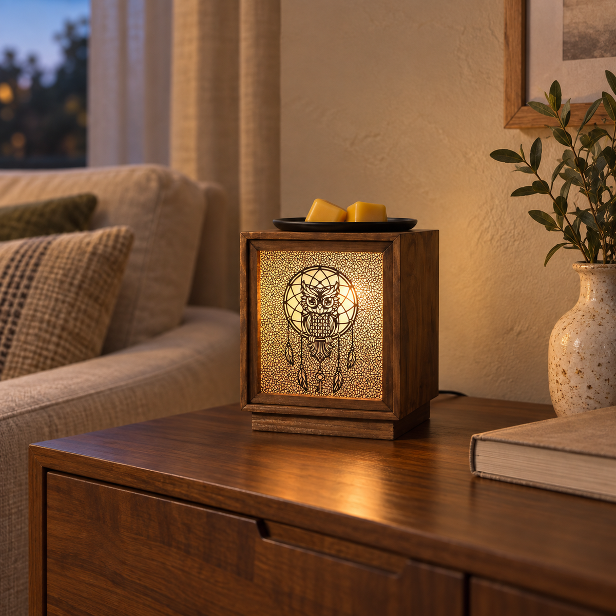 Wooden owl electric wax warmer glowing on a cabinet in a warm living room setting.