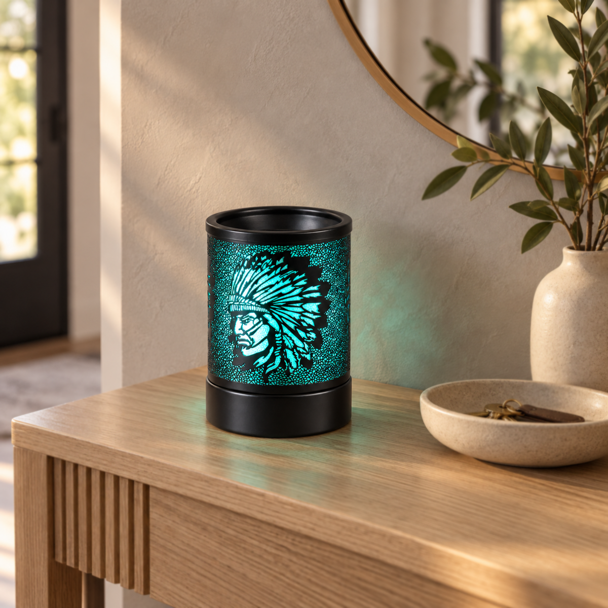 Green glowing wax warmer with a feathered headdress design displayed on a light wood entryway console.