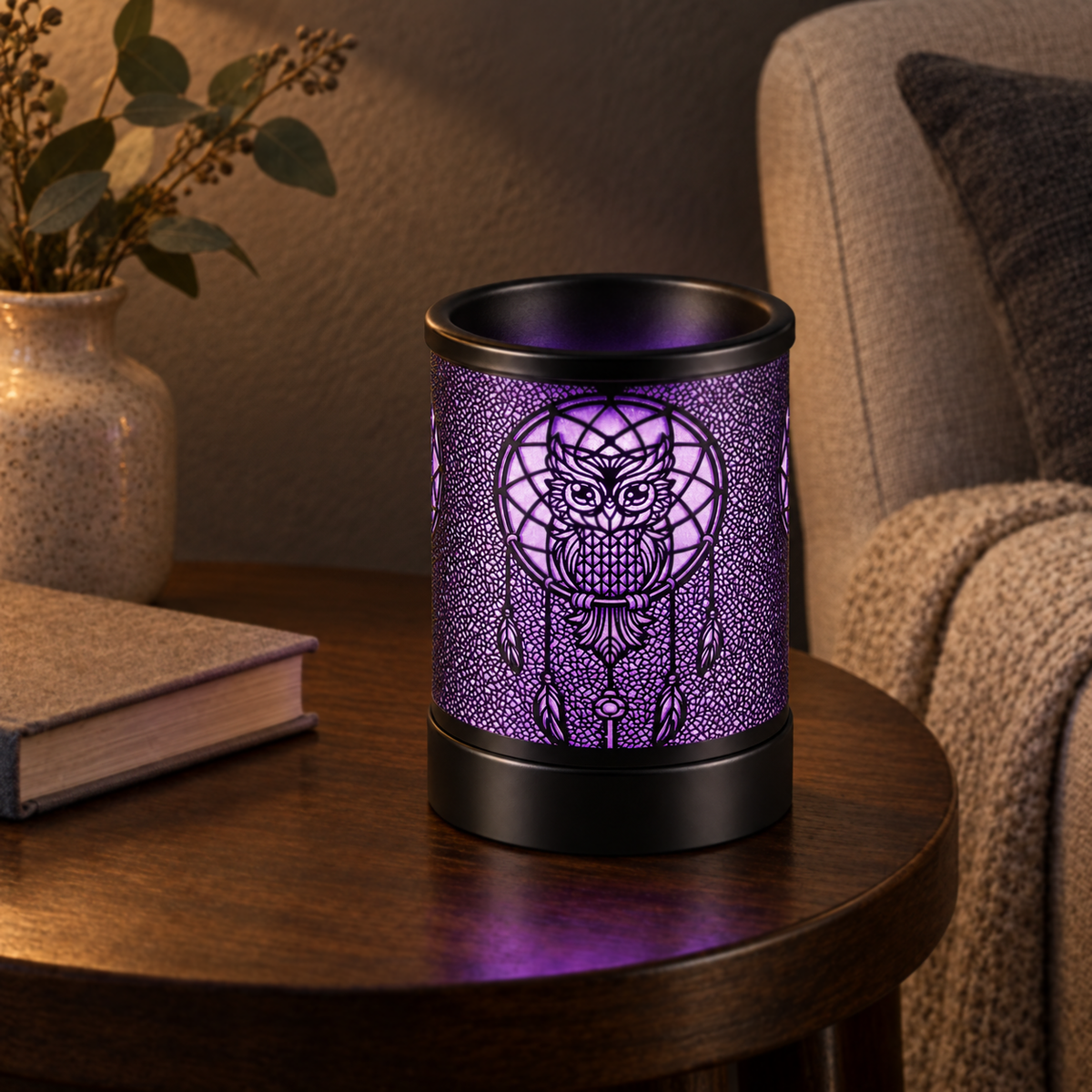 Purple glowing owl dreamcatcher wax warmer displayed in a cozy reading corner