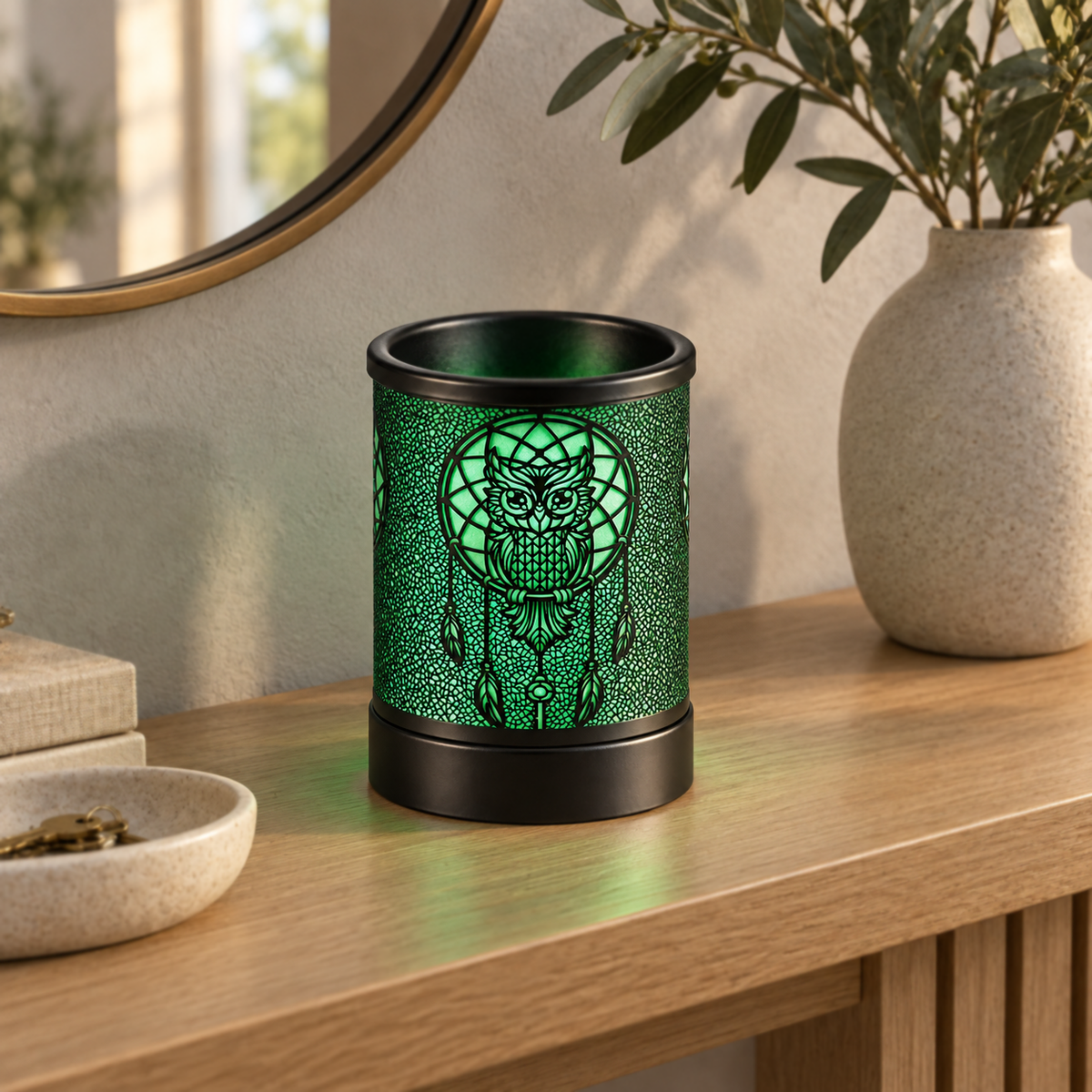 Green glowing owl dreamcatcher wax warmer displayed on a light wood entryway console