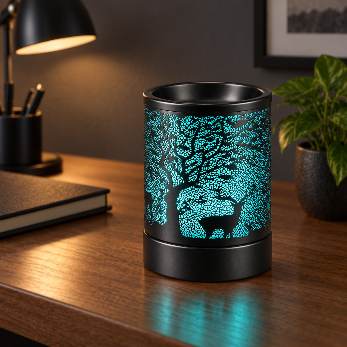 Turquoise glowing deer and tree wax warmer displayed on a wooden home office desk.