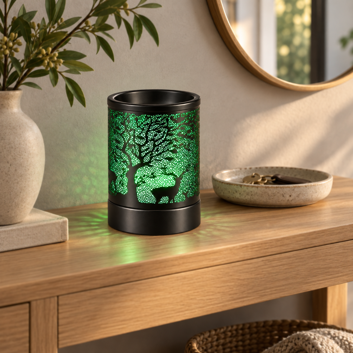 Green glowing deer and tree wax warmer displayed on a light wood entryway console.