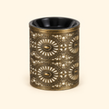 Vintage bronze electric wax warmer with a black dish and ornate floral cutout design, switched off on a cream background.