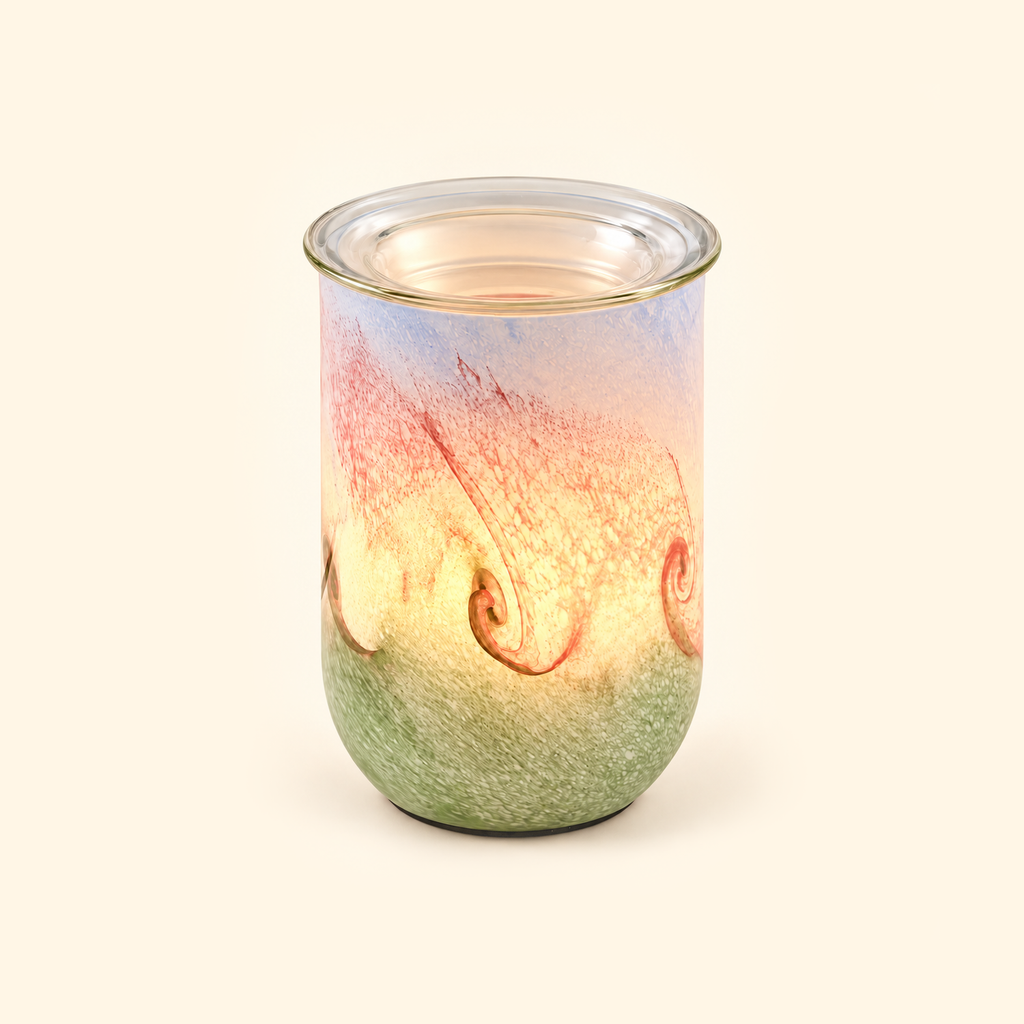 Blush Sage Swirl glass illumination wax warmer glowing warmly on a cream background.