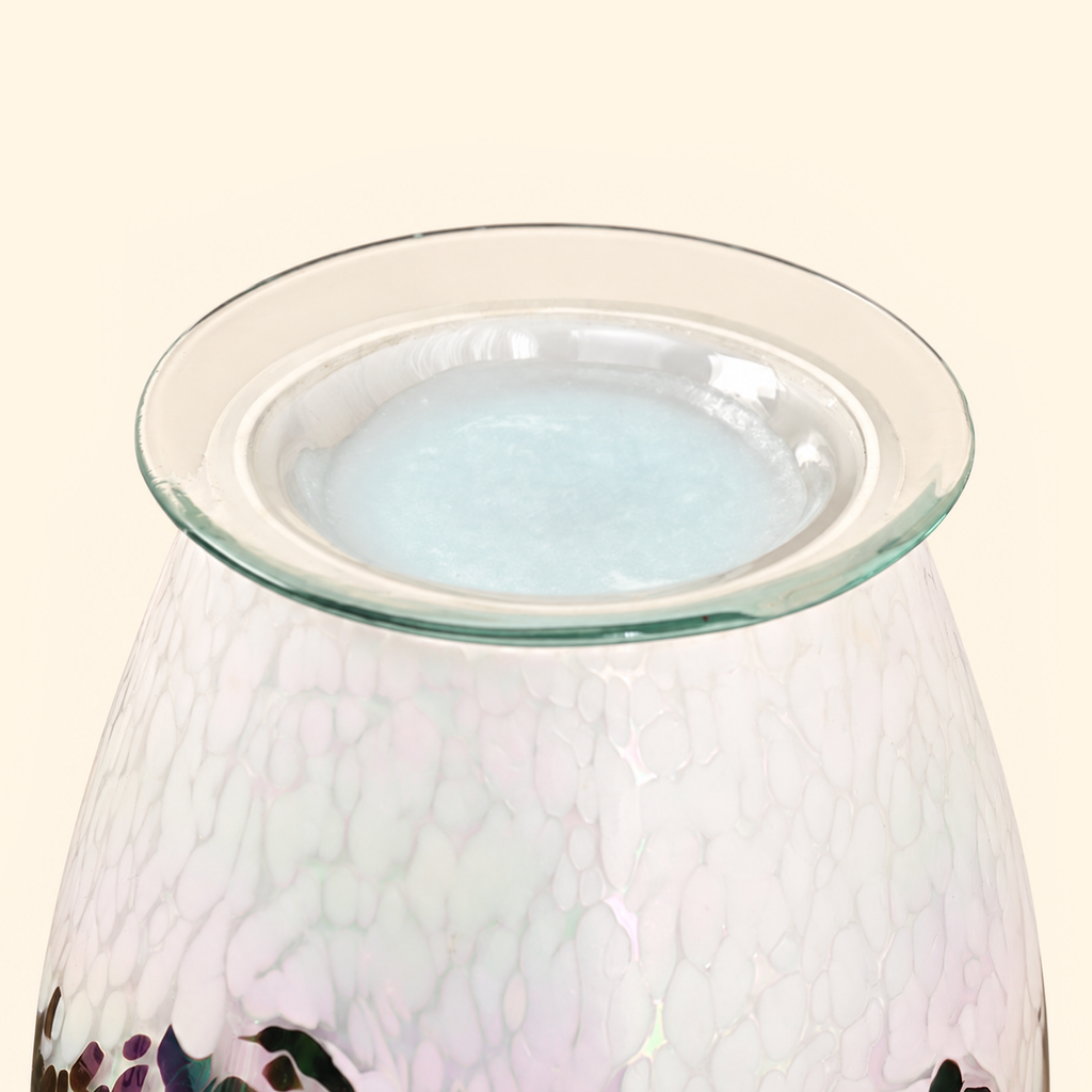 Close-up of the clear glass dish with pale blue melted wax on the Prismatic Tide warmer.