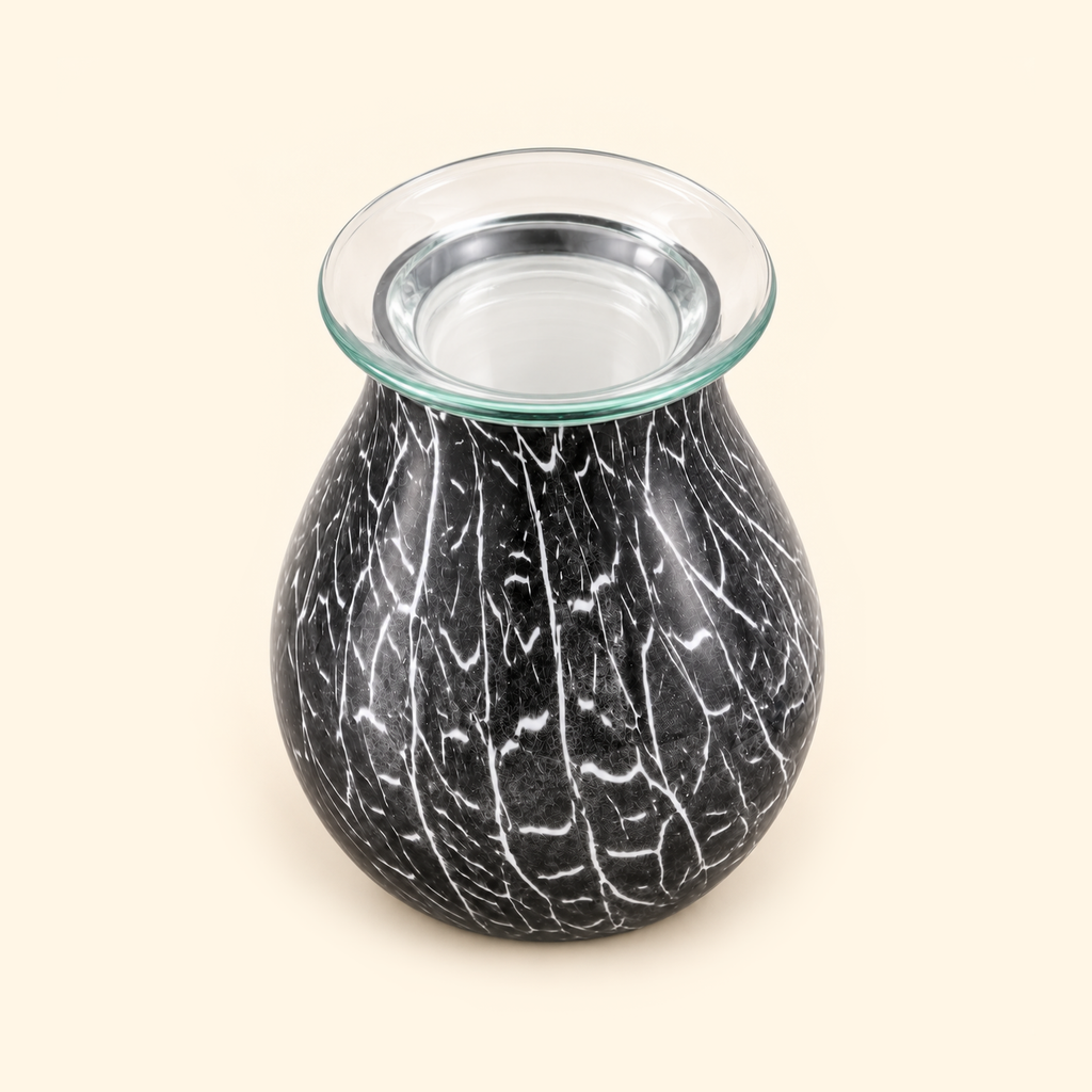 Elevated view of the clear wax dish and smoky crackle glass body of the illumination wax warmer.