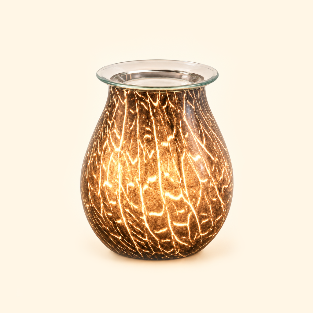 Smoked Crackle Glass Illumination Wax Warmer glowing with warm amber light on a warm cream background.