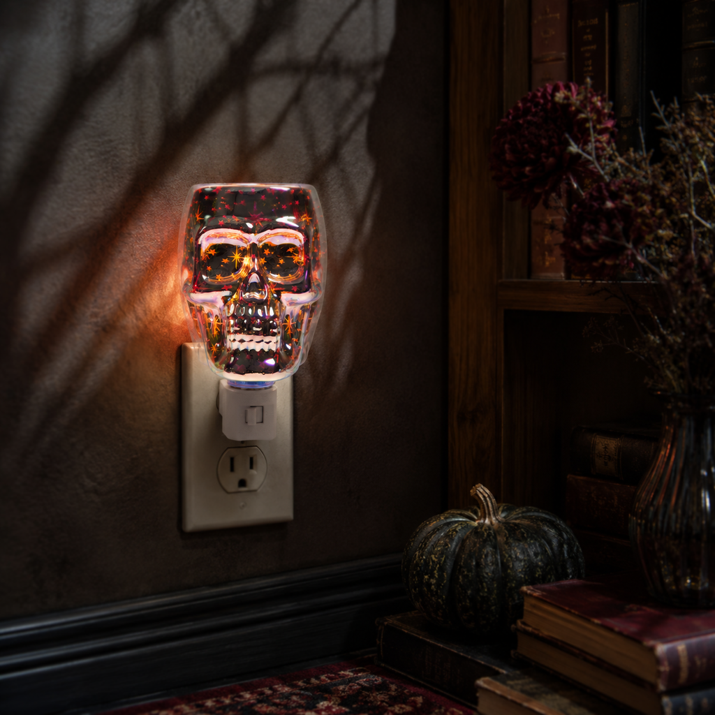 Halloween plug-in wax warmer displayed beside autumn decor in a dark seasonal interior.