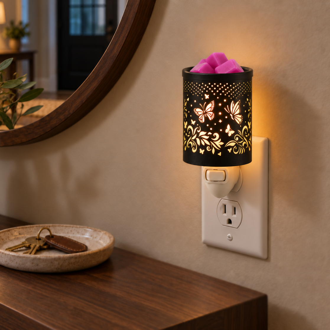 Butterfly Vine plug-in wax warmer casting a warm glow beside a mirror and wooden console table.