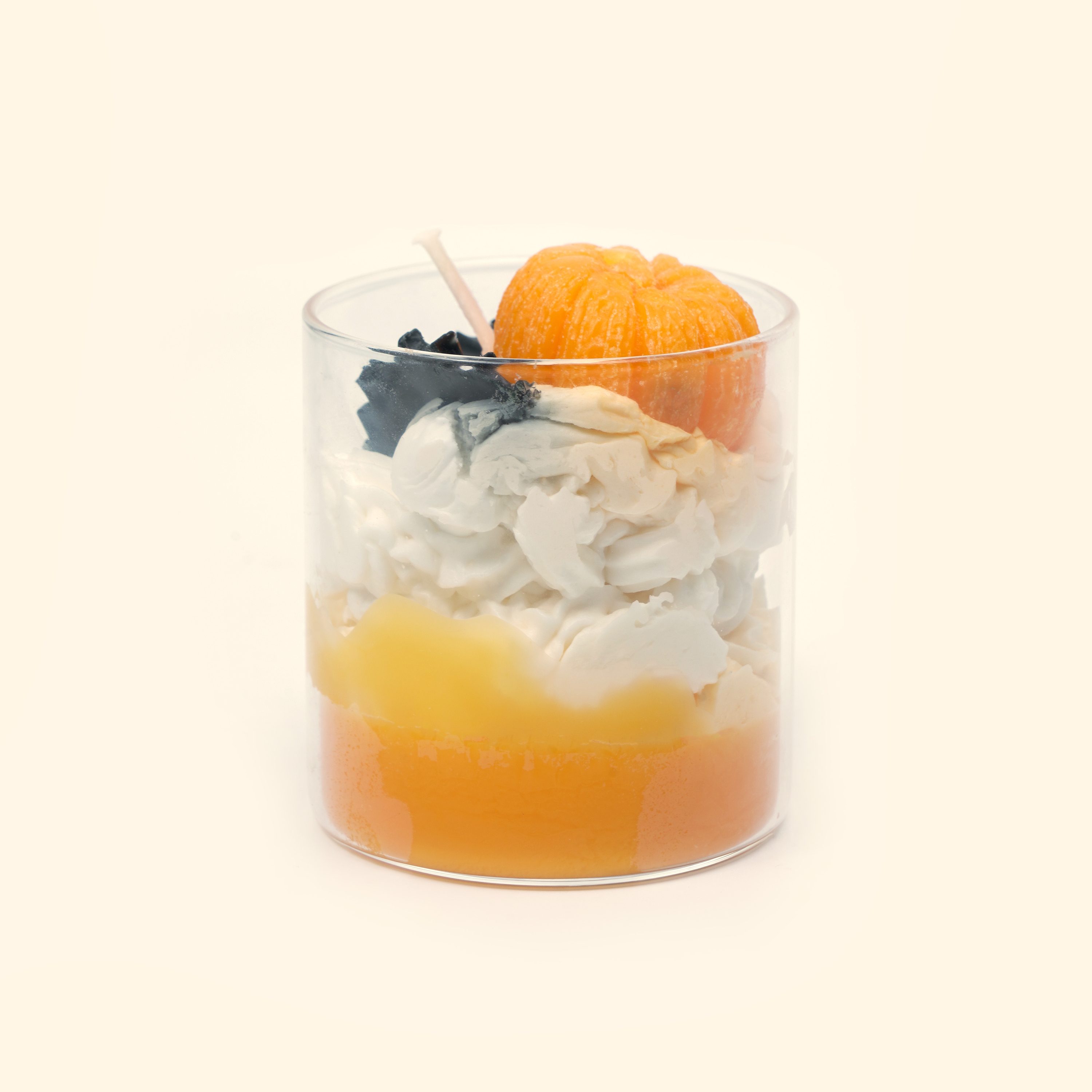 Pumpkin & Bat Halloween Candle in a clear cylindrical glass cup with a sculpted orange pumpkin, black bat wax details and cream-colored piped wax.