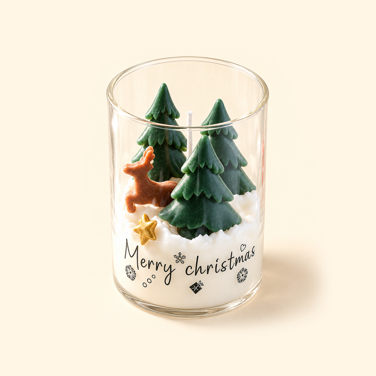 Angled top view of an open Christmas Woodland candle showing a brown deer, three green wax trees and a gold star.