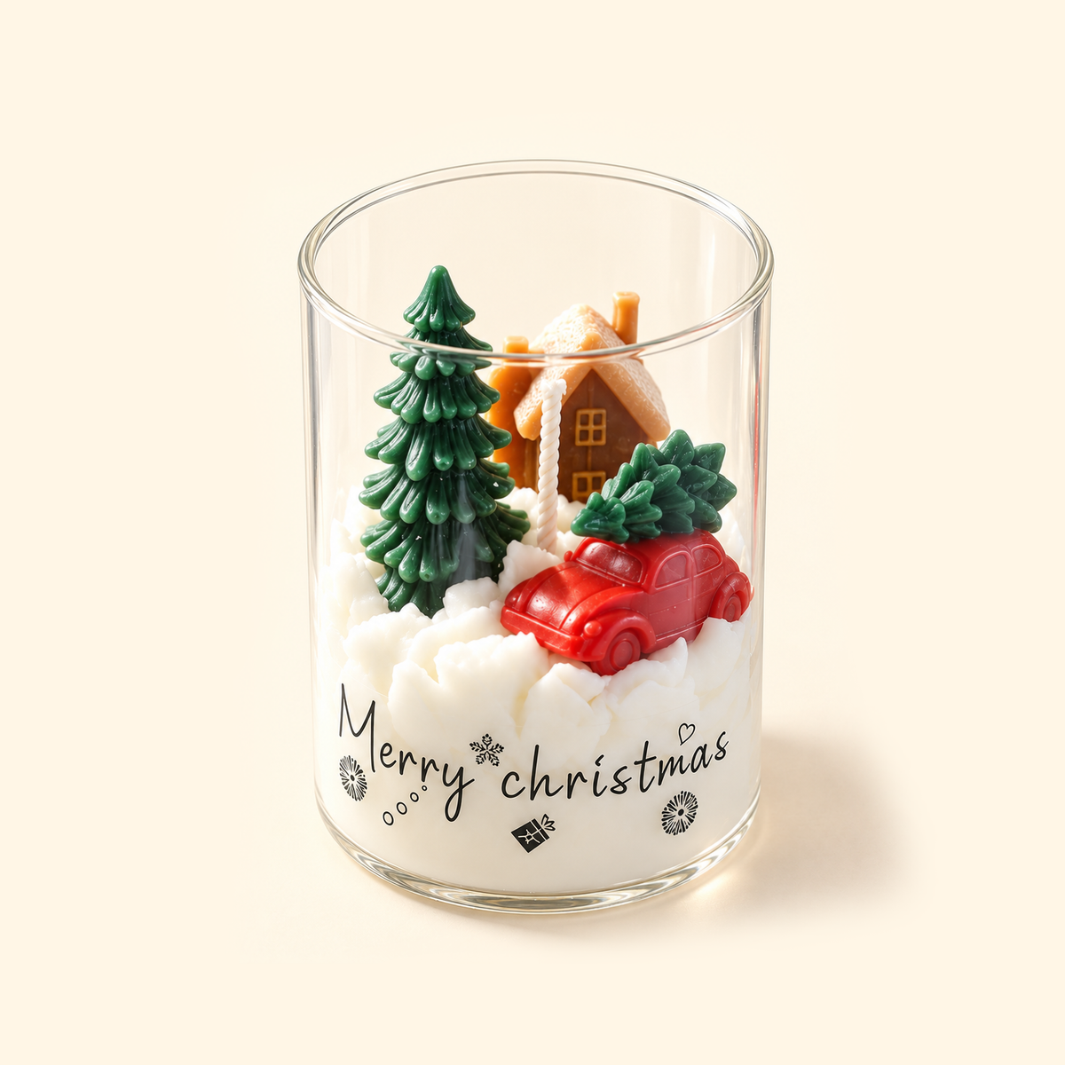 Angled top view of an open Christmas Village candle with a wax cottage, red car carrying a tree and snowy white wax.