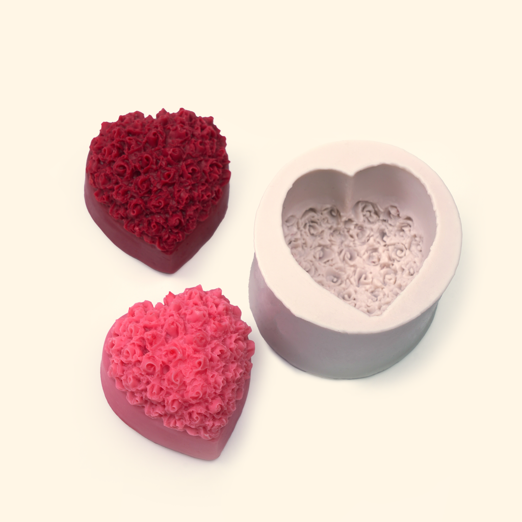 Heart-shaped silicone mold displayed beside sample finished wax pieces showing the embossed floral design.