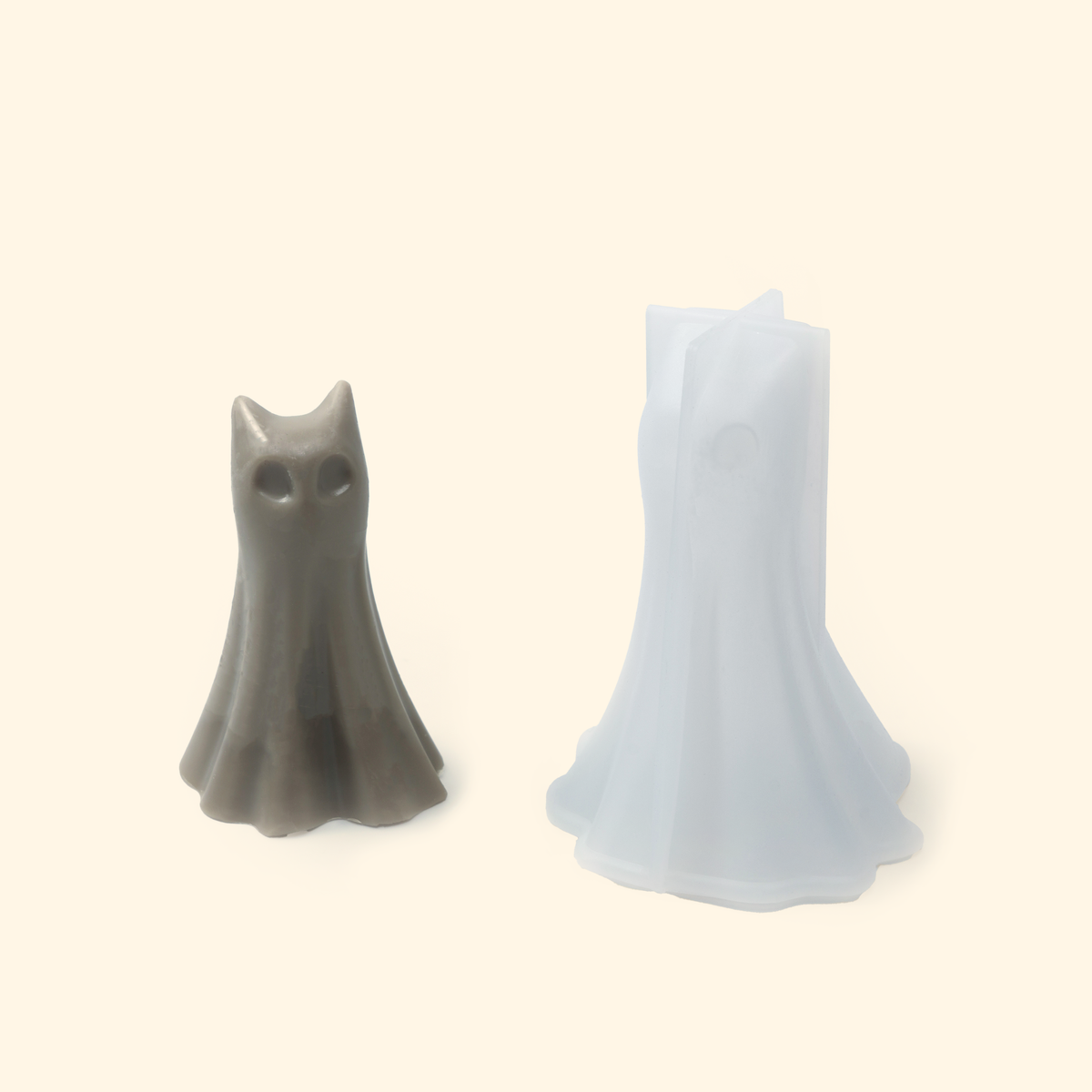 Translucent silicone ghost mold displayed beside a sample finished wax piece showing the detailed ghost shape.