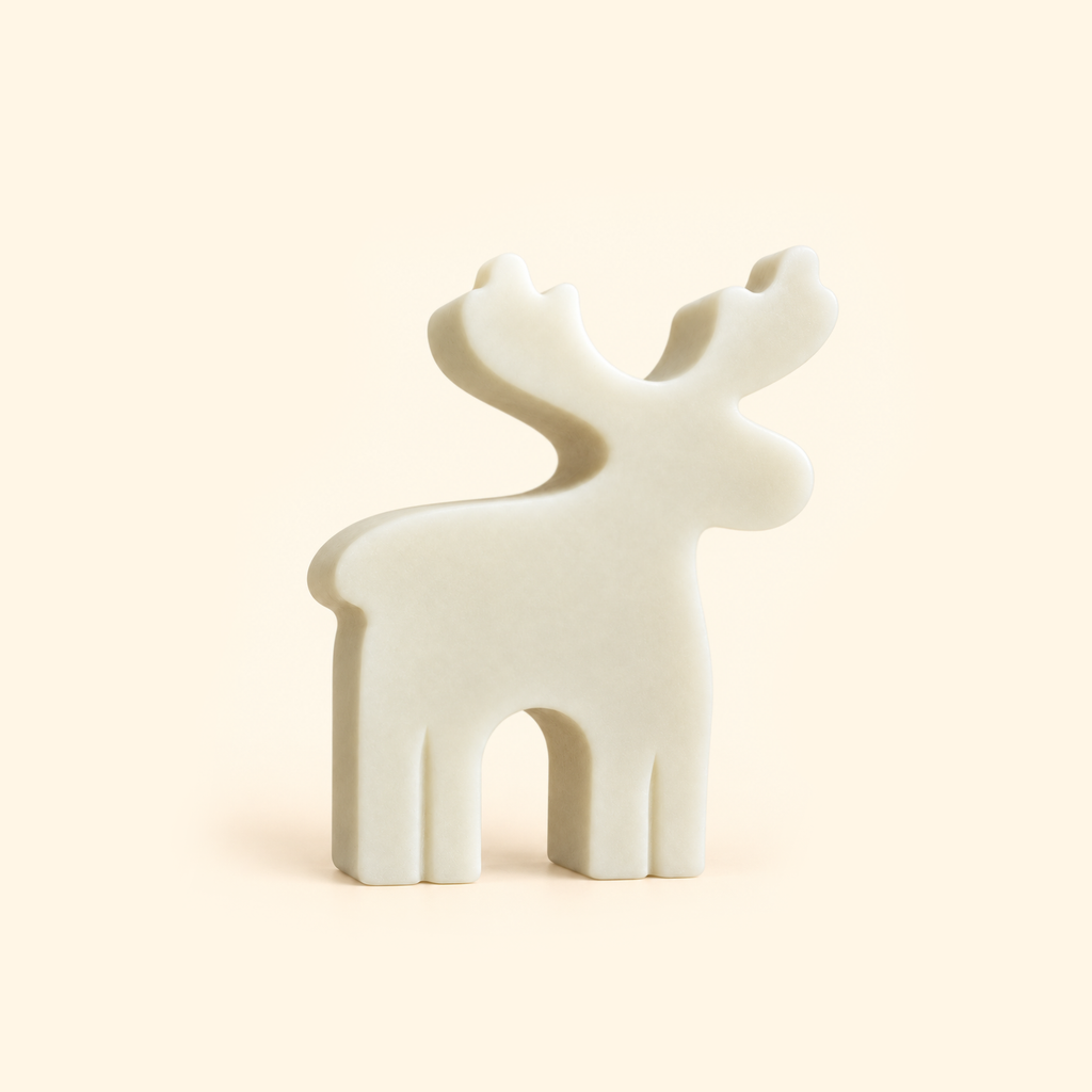 Ivory reindeer casting with branching antlers and a simple flat profile on a cream background.