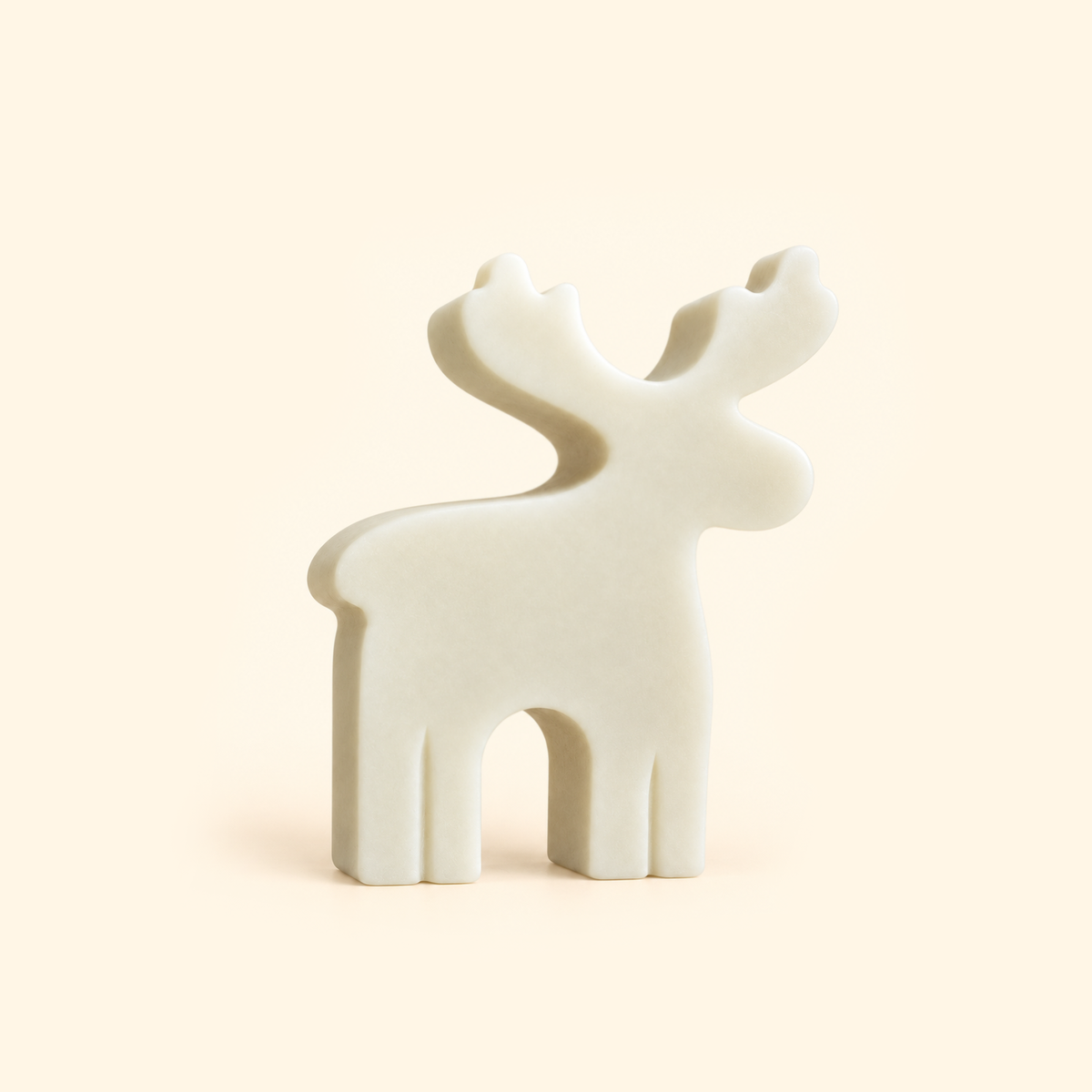 Ivory reindeer casting with branching antlers and a simple flat profile on a cream background.
