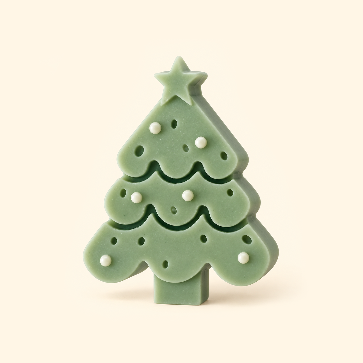 Sage green Christmas tree casting with a star topper, white baubles and scalloped tiers on a cream background.