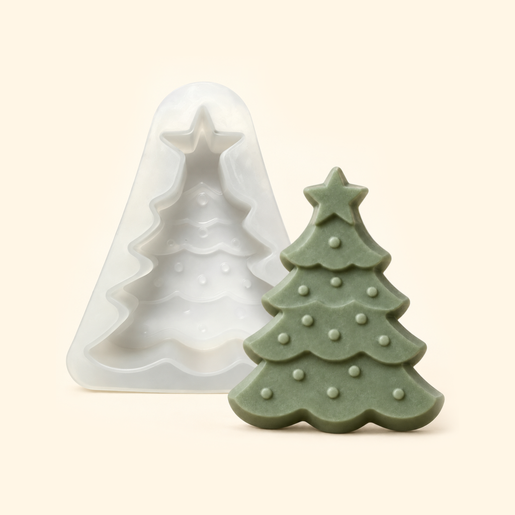 White Christmas tree silicone mold beside a muted green casting with a star topper and raised bauble details.