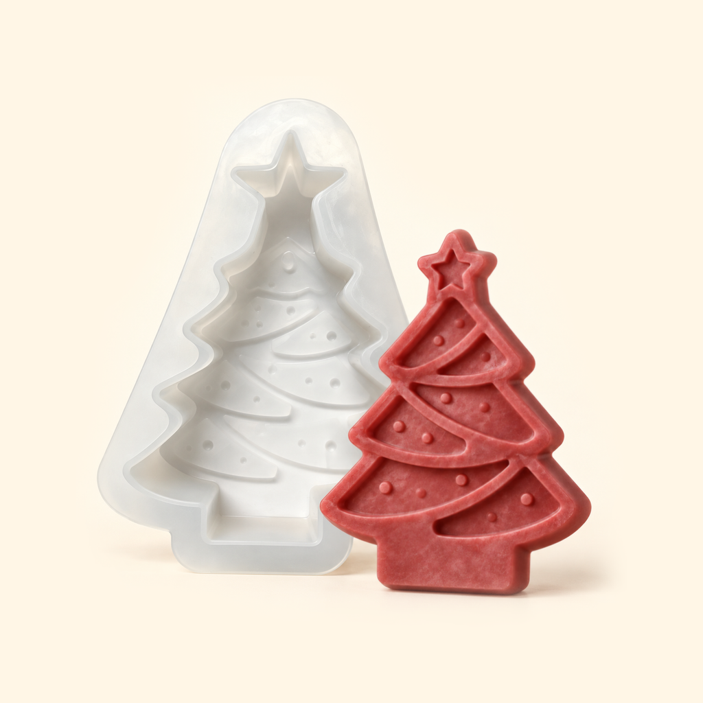 White Christmas tree silicone mold beside a muted red casting with a star topper and curved garland relief.