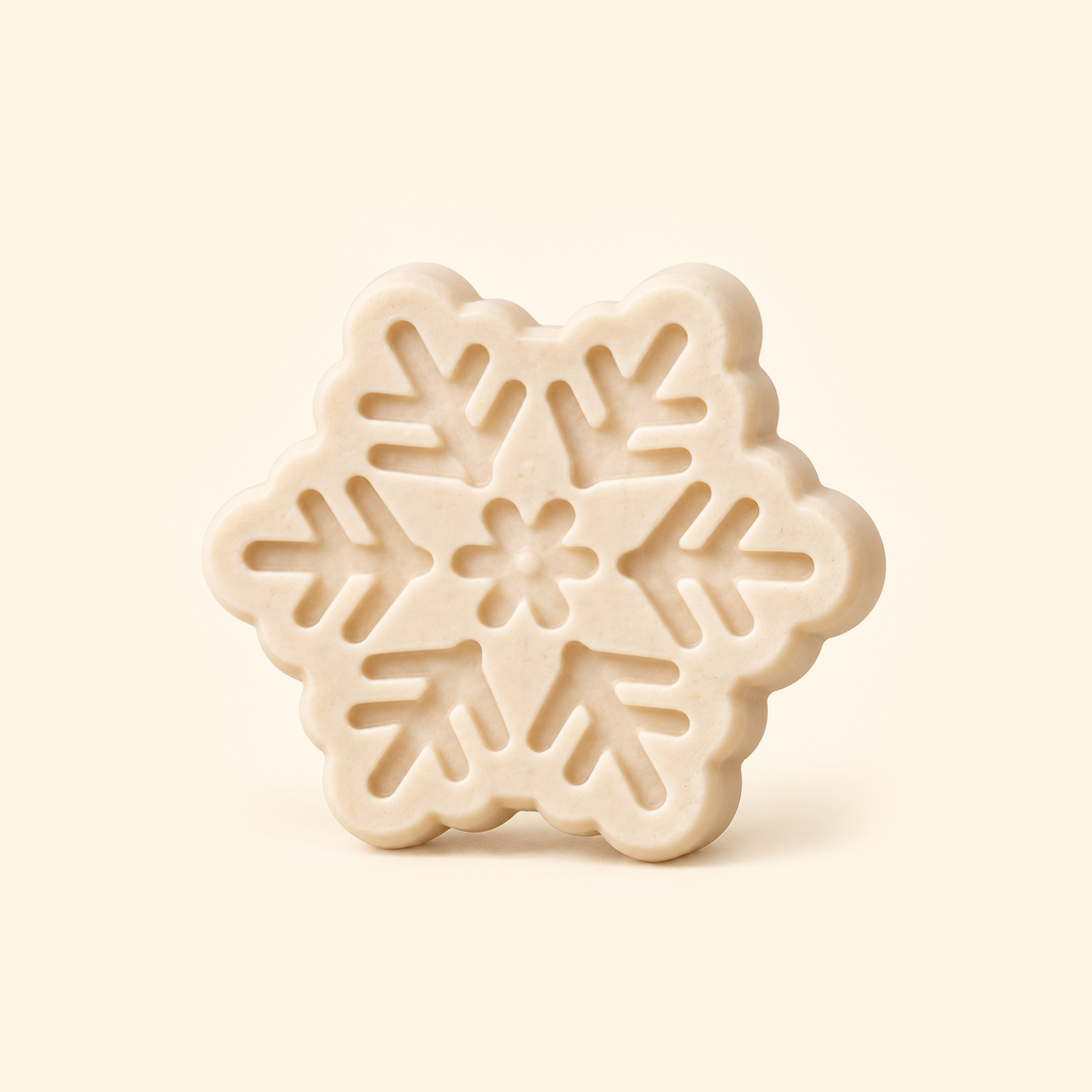 Ivory snowflake casting with six branching arms, recessed geometric details and a floral center on a cream background.