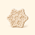 Ivory snowflake casting with six branching arms, recessed geometric details and a floral center on a cream background.