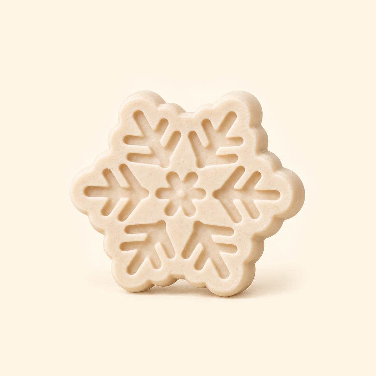 Ivory snowflake casting with six branching arms, recessed geometric details and a floral center on a cream background.