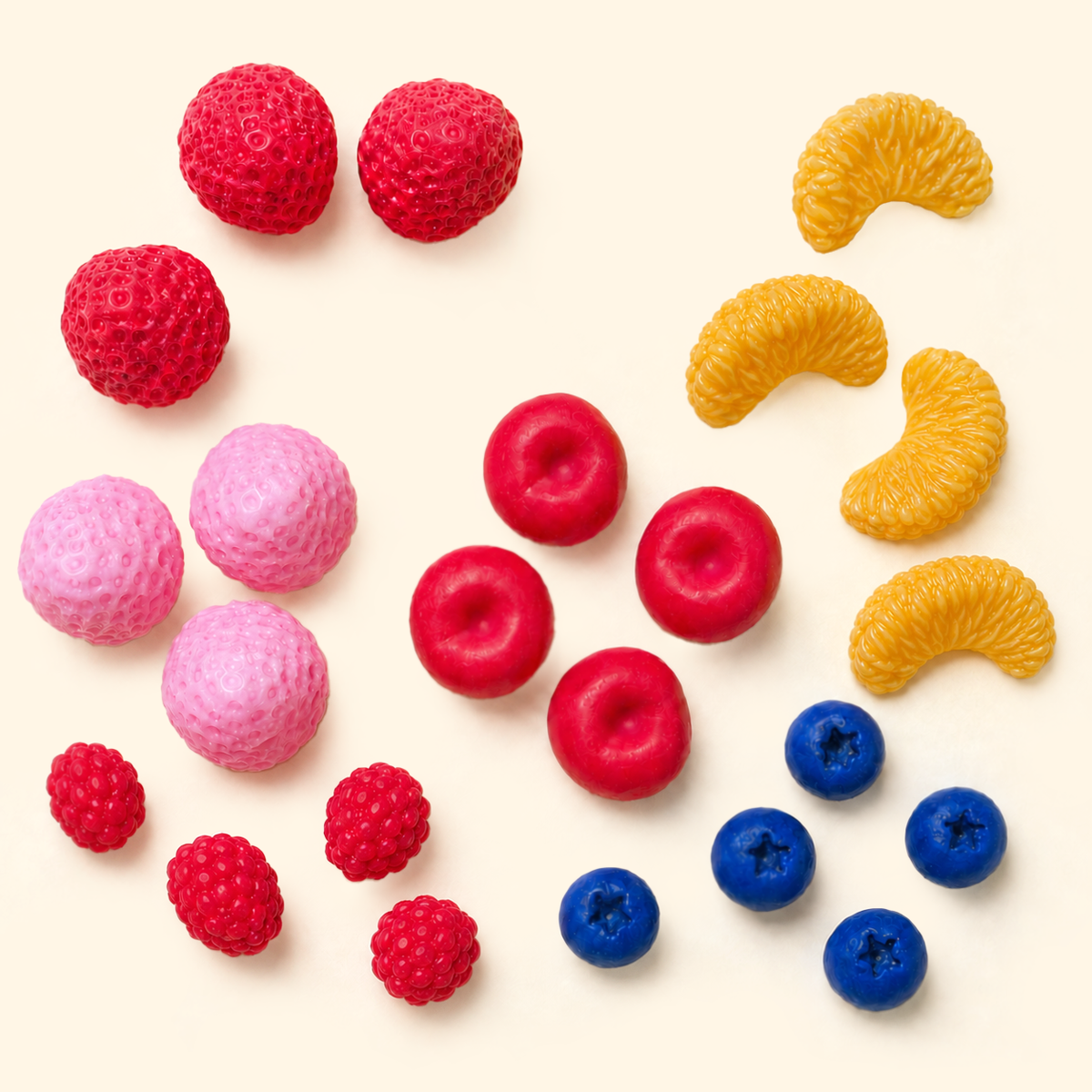 Mixed Fruit Wax Melts in blueberry, strawberry, orange, cherry and raspberry shapes arranged on a light cream background.