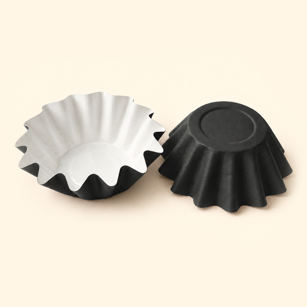Black disposable wax melt liners with white interiors, shown open and upside down on a warm ivory background